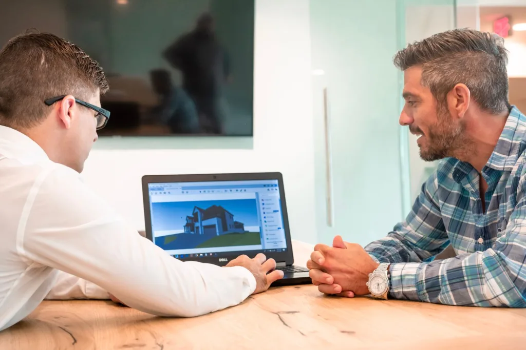 Two colleagues discussing a project at a laptop